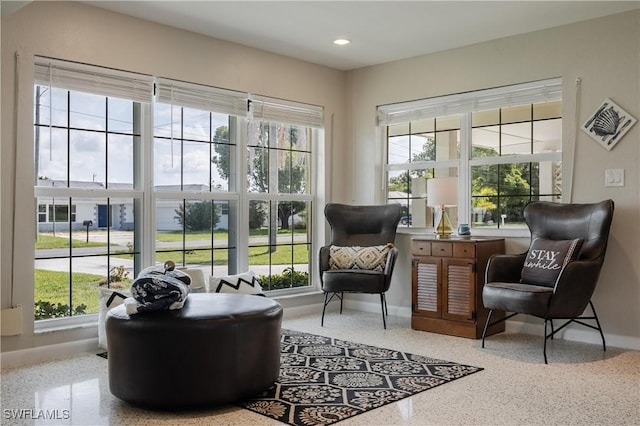 living area with recessed lighting, baseboards, and speckled floor