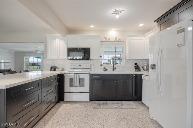 kitchen featuring white cabinets, decorative backsplash, white appliances, and a wealth of natural light