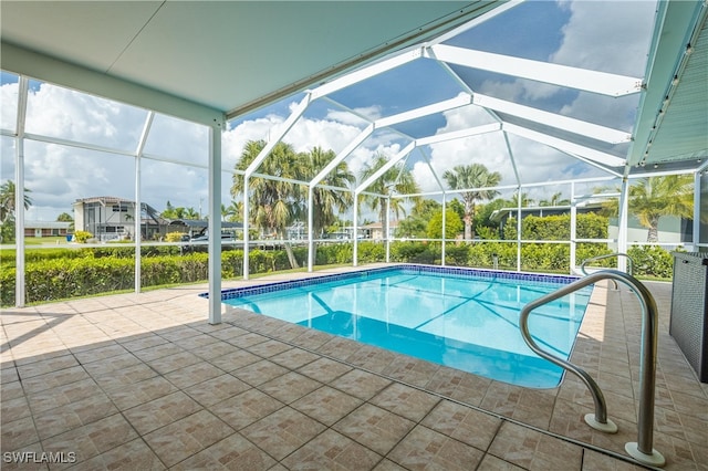 view of swimming pool featuring glass enclosure and a patio