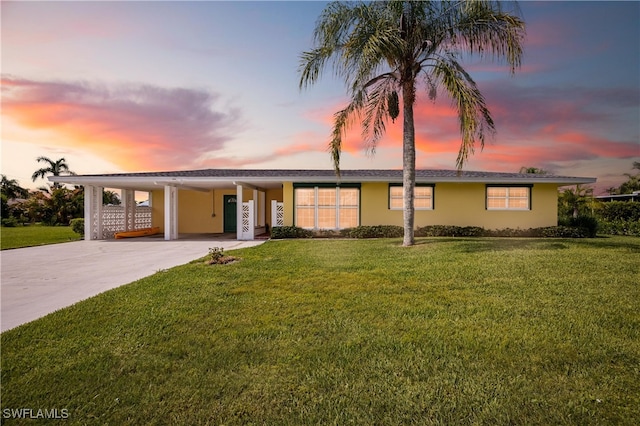 ranch-style home with a carport and a lawn