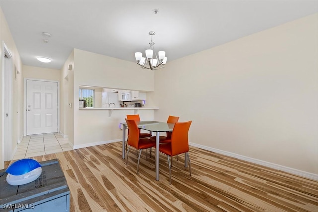 14831 Park Lake Dr Unit 309, Fort Myers, FL 33919 - dining space with a chandelier, light wood-type flooring, and baseboards