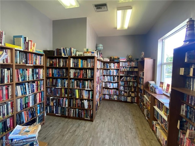 14831 Park Lake Dr Unit 309, Fort Myers, FL 33919 - living area featuring visible vents, bookshelves, and wood finished floors
