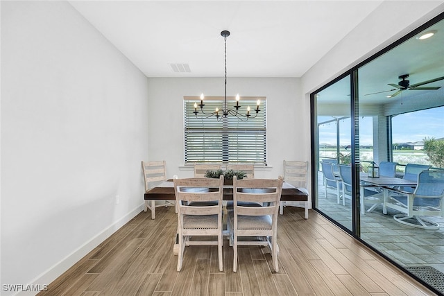 dining area with ceiling fan with notable chandelier