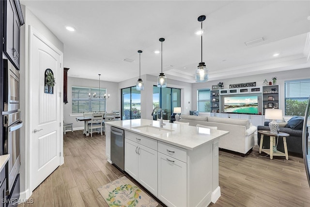 kitchen featuring white cabinetry, decorative light fixtures, a raised ceiling, and sink