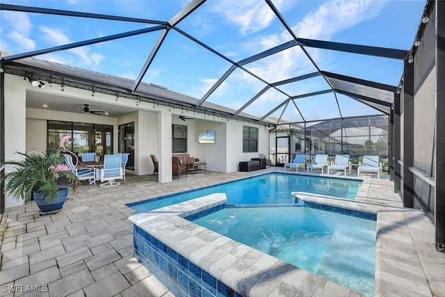 view of swimming pool with a patio, a lanai, an in ground hot tub, and ceiling fan