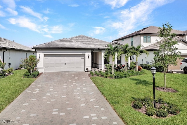 view of front of house featuring a front yard, decorative driveway, an attached garage, and stucco siding