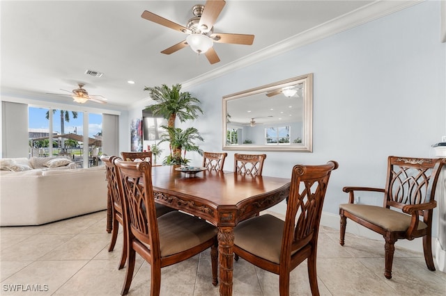 tiled dining space with ceiling fan and ornamental molding