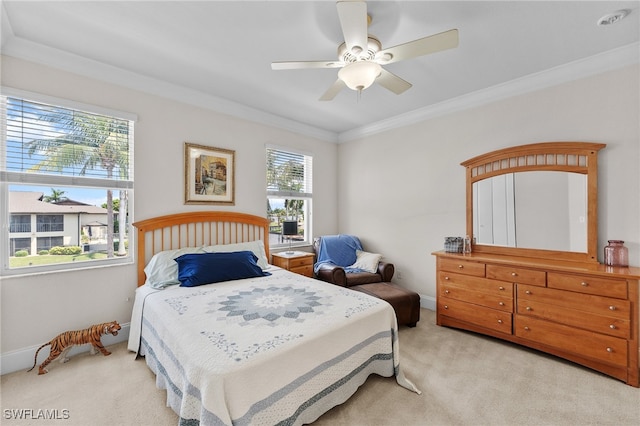 carpeted bedroom featuring ceiling fan and crown molding