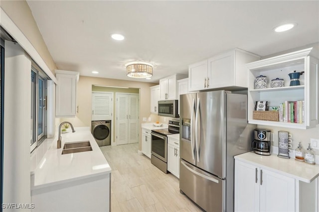 kitchen with stainless steel appliances, washer / clothes dryer, sink, and white cabinets