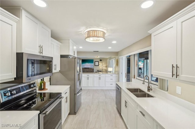 kitchen with stainless steel appliances, white cabinetry, and sink