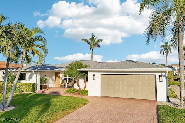 ranch-style home with a garage and a front lawn