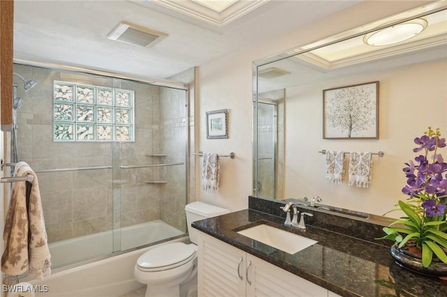 full bathroom with vanity, enclosed tub / shower combo, and toilet