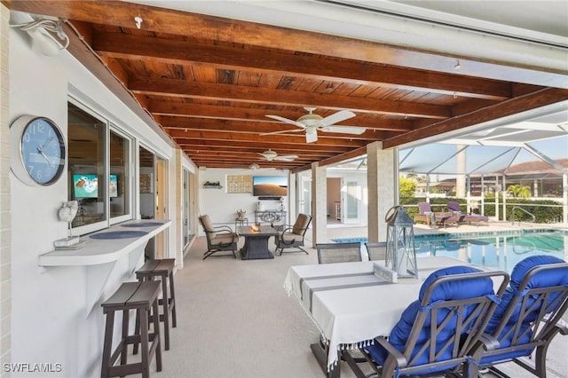 view of patio / terrace with a bar, an indoor pool, and an outdoor fire pit