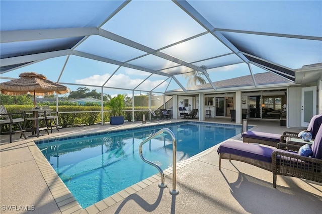 view of pool with glass enclosure and a patio area