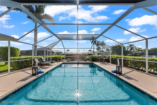 view of pool with a patio and glass enclosure