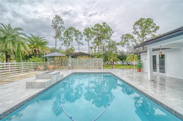 view of swimming pool with a patio, french doors, fence, and a fenced in pool