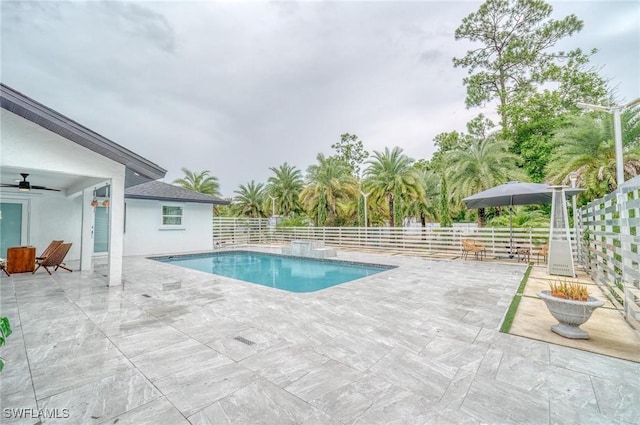 view of swimming pool with ceiling fan and a patio area