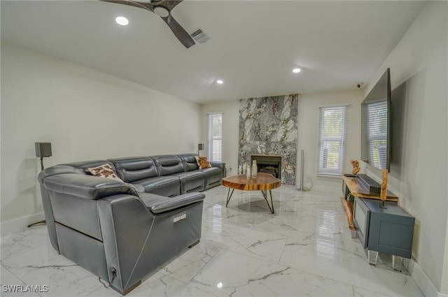 living room with plenty of natural light, ceiling fan, and a fireplace