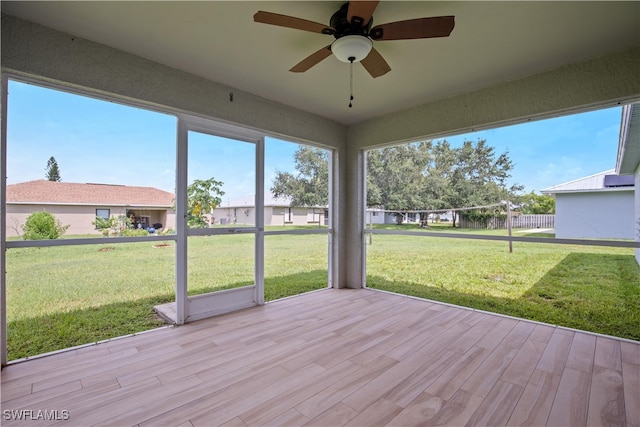 unfurnished sunroom with ceiling fan