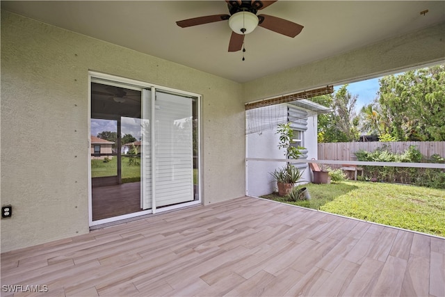 unfurnished sunroom with ceiling fan