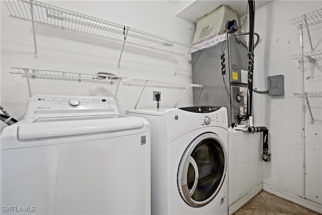 laundry area with washer and dryer and light tile patterned floors