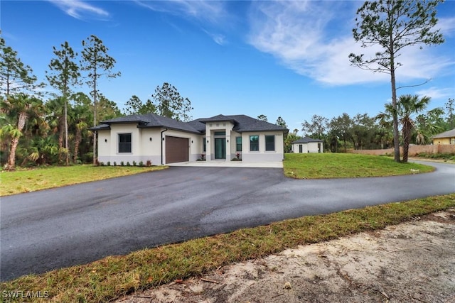 prairie-style home with a front yard and a garage