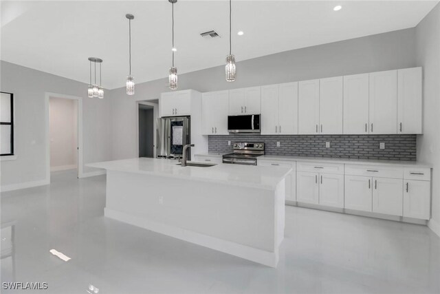 kitchen with appliances with stainless steel finishes, decorative backsplash, a center island with sink, pendant lighting, and white cabinets