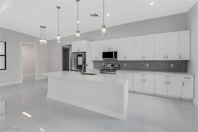 kitchen with a center island with sink, hanging light fixtures, stainless steel appliances, and white cabinets