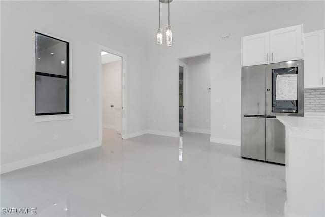 unfurnished dining area featuring a high ceiling and an inviting chandelier