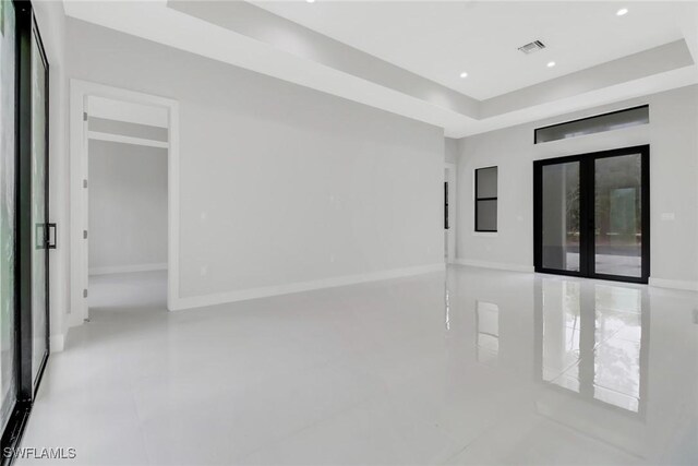 tiled spare room with a tray ceiling