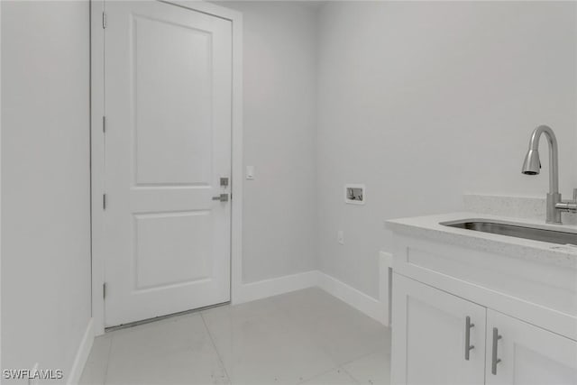 laundry area with light tile patterned flooring, sink, hookup for a washing machine, and cabinets