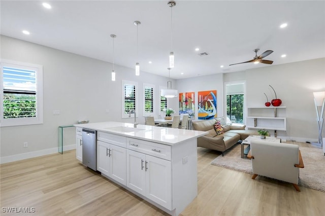 kitchen with a healthy amount of sunlight, dishwasher, white cabinetry, and a sink