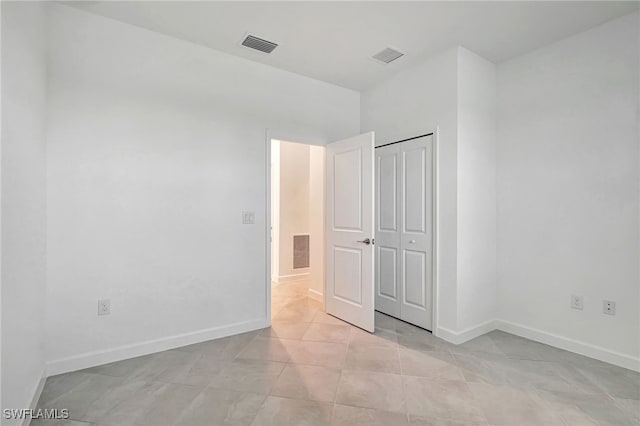 unfurnished bedroom featuring a closet and light tile patterned floors