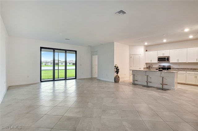 unfurnished living room featuring light tile patterned flooring, baseboards, visible vents, and recessed lighting