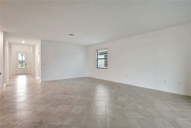 empty room featuring visible vents, baseboards, and light tile patterned flooring