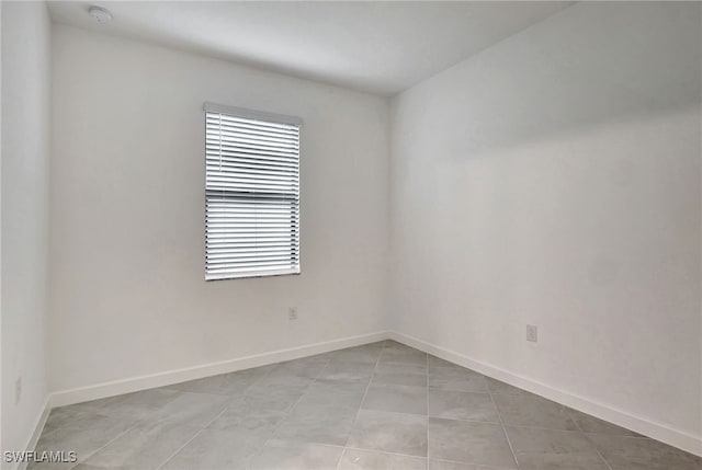 unfurnished room with baseboards