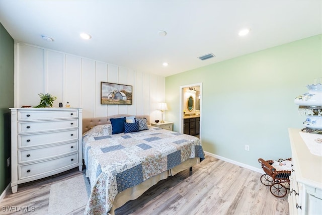 bedroom featuring ensuite bath and light wood-type flooring