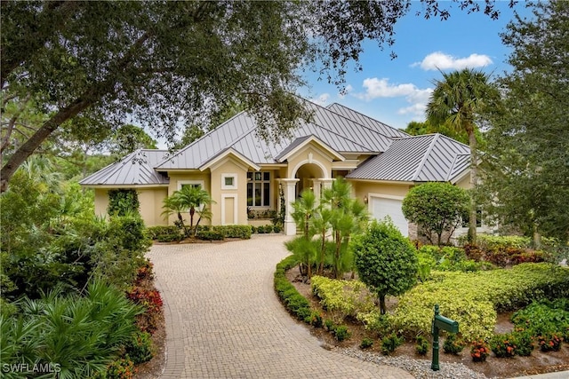 view of front of house with a garage, a standing seam roof, and metal roof