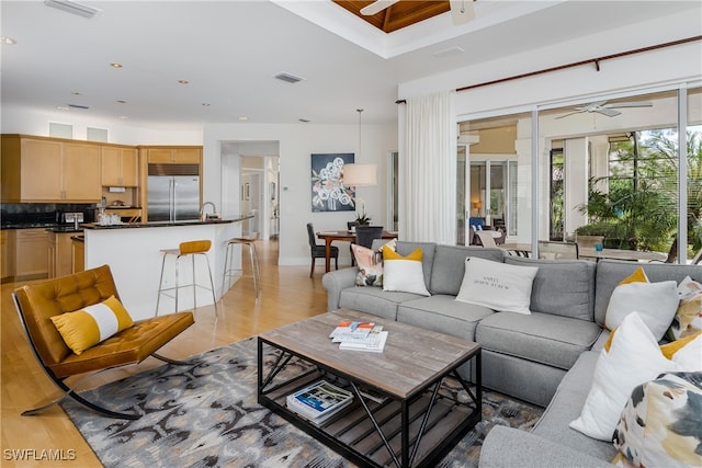 living room featuring ceiling fan and light hardwood / wood-style floors