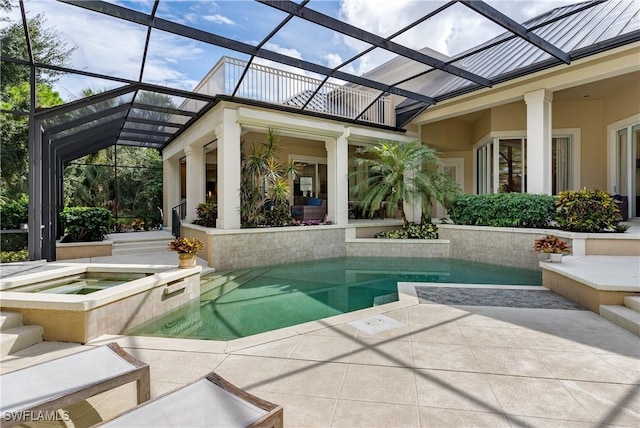 view of pool with a patio area, a lanai, and a pool with connected hot tub