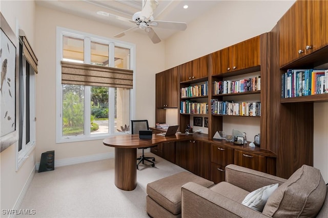 office space featuring ceiling fan, baseboards, and light colored carpet