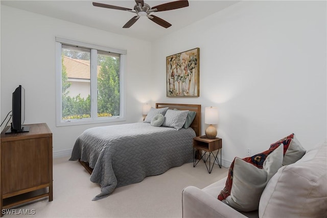 bedroom featuring light carpet, ceiling fan, and baseboards