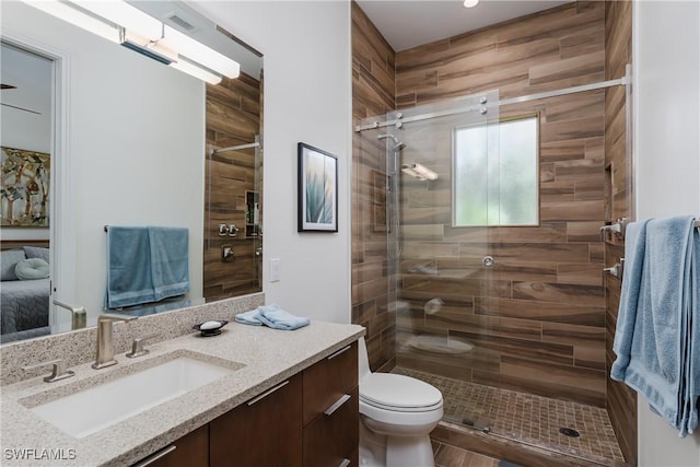 bathroom featuring toilet, a stall shower, visible vents, and vanity