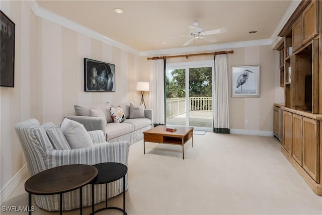 living area with light carpet, baseboards, ornamental molding, and ceiling fan