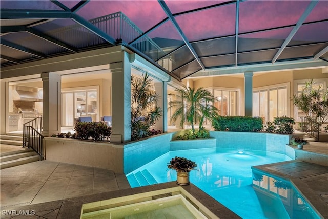 pool featuring a patio area, an outdoor kitchen, and an in ground hot tub