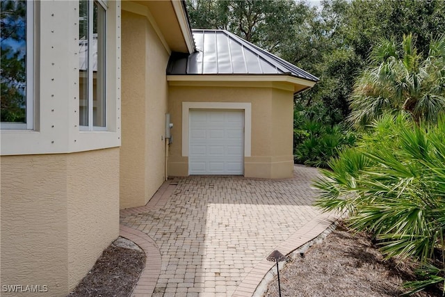 exterior space with a standing seam roof, metal roof, and stucco siding