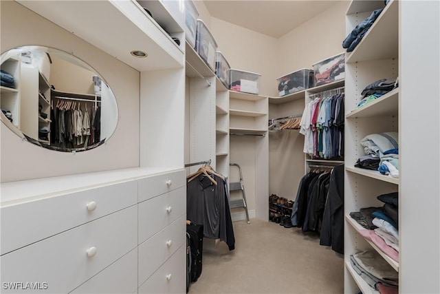 walk in closet featuring light colored carpet