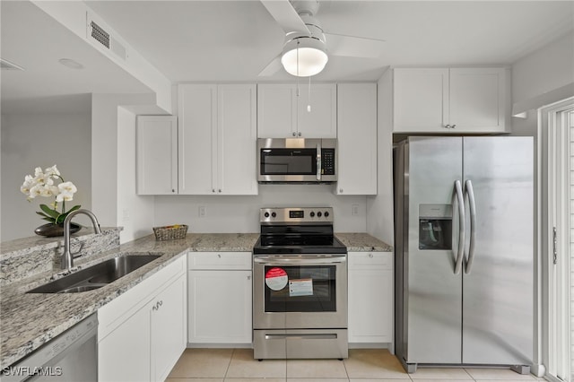 kitchen featuring ceiling fan, white cabinetry, appliances with stainless steel finishes, light stone countertops, and sink