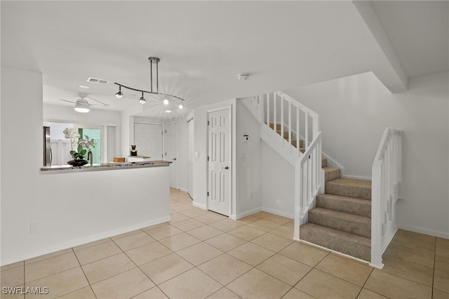 interior space with light tile patterned floors, track lighting, and ceiling fan