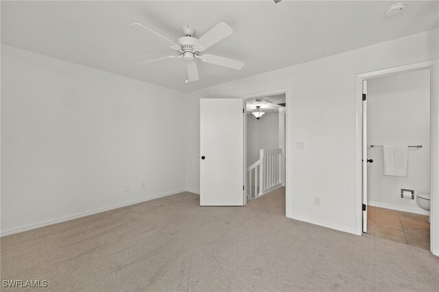 unfurnished bedroom featuring ceiling fan, light carpet, and ensuite bathroom